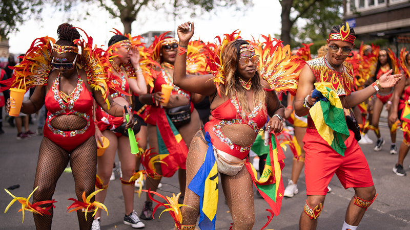 Party on at London’s Notting Hill Carnival in August. Credit: Shutterstock. Image courtesy of Shutterstock. A group of carnival-goers with feathered wings and bright attire at Notting Hill Carnival