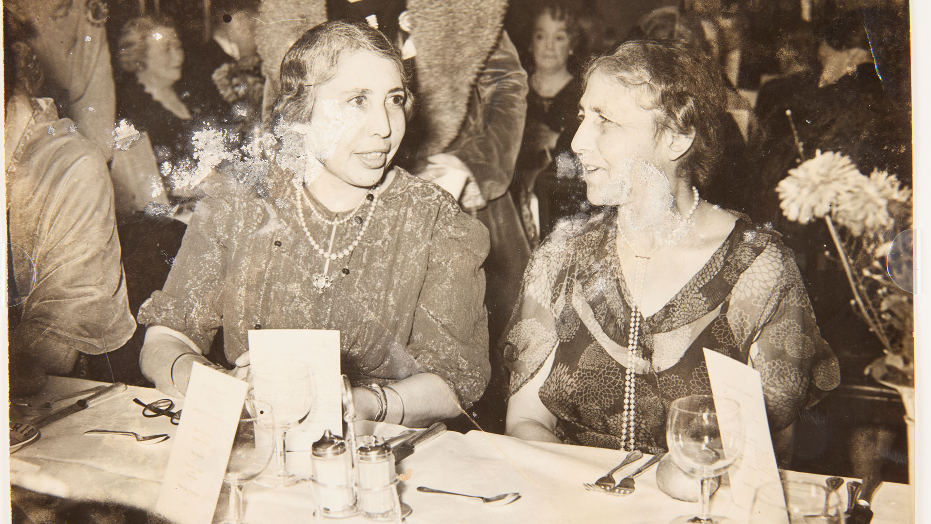 Unmounted silver print photograph of Princesses Sophia and Catherine Duleep Singh at a Suffrage dinner on the anniversary of the first time Christabel Pankhurst and Annie Kenney were arrested in Manchester, 1930. Image courtesy of Kensington Palace/ photo credit: © Peter Bance Collection Unmounted silver print photograph of Princesses Sophia and Catherine Duleep Singh at a Suffrage dinner on the anniversary of the first time Christabel Pankhurst and Annie Kenney were arrested in Manchester, 1930.