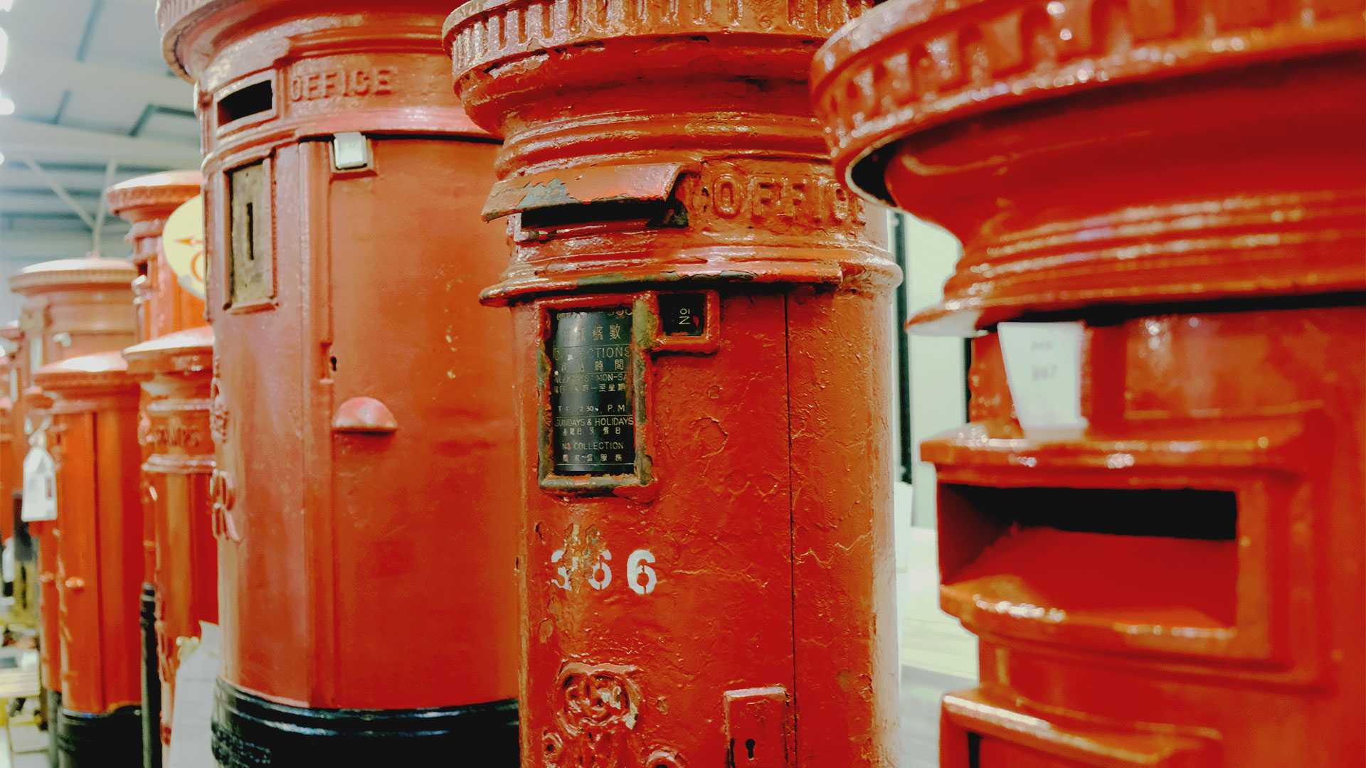 Uncover the fascinating history of Britain's postboxes by visiting the Postal Museum Store. Photo credit: Carole Rocton. A close-up of a line of red cast-iron post boxes, including a Hong Kong post box with instructions in both English and Chinese.