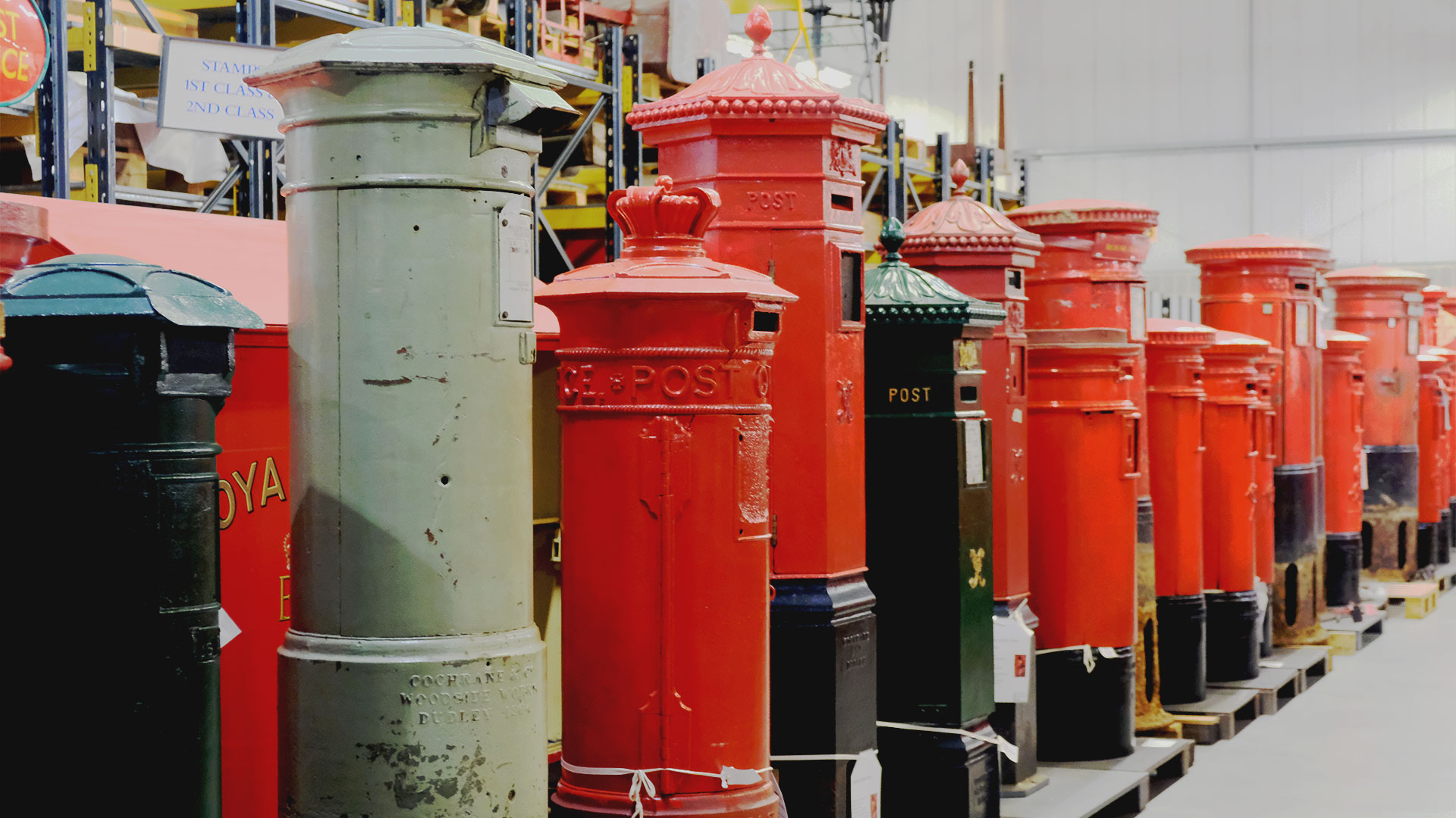 Join the behind-the-scenes tour at the Postal Museum Store in Debden to discover more than 150 years of postal services. Photo credit: Carole Rocton. There is a long row of cast-iron post boxes, ranging in colour from dark green to light green and the iconic red.