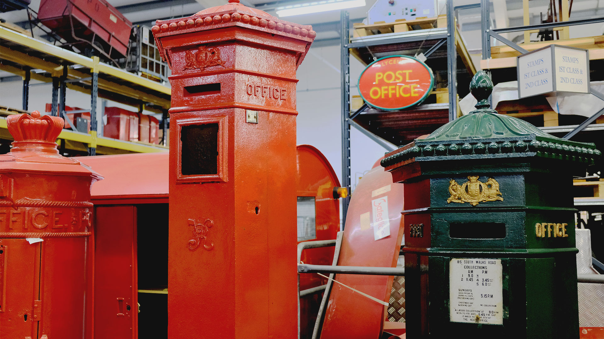 Discover the origins of cyphers on red post boxes with a visit to London's Postal Museum Store, where you can learn how to recognise them. Photo credit: Carole Rocton. Red cast iron post boxes of different designs are lined up, including the Liverpool post box on the far left, which has a crown at its top.