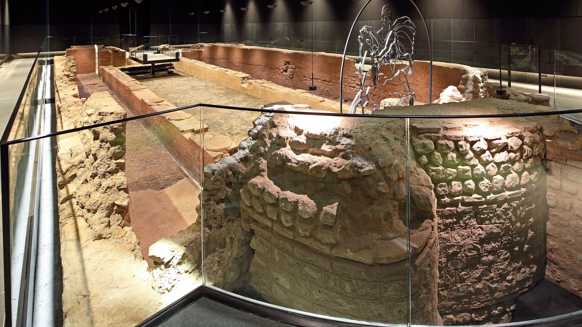 Explore the reconstructed Temple of Mithras in London © PAYE Conservation. Image courtesy of London Mithraeum Bloomberg Space. Part of the ruins of the Temple of Mithras illuminated at the London Mithraeum.