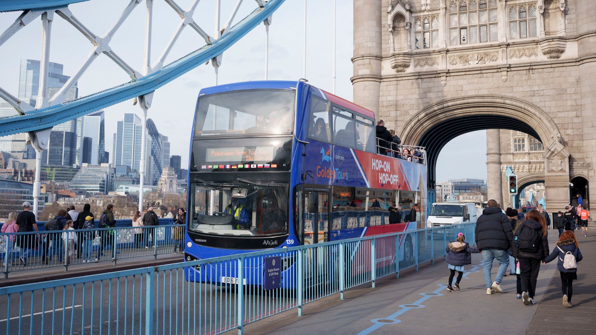 See London’s famous attractions aboard a hop-on hop-off bus tour. Image courtesy of Golden Tours. Open-top bus driving across Tower Bridge.