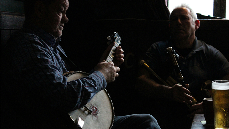Listen to live music as you enjoy the vibrant atmosphere of an Irish pub in London. Credit: Morgan Lane. Image courtesy of Unsplash. Two musicians in an Irish pub