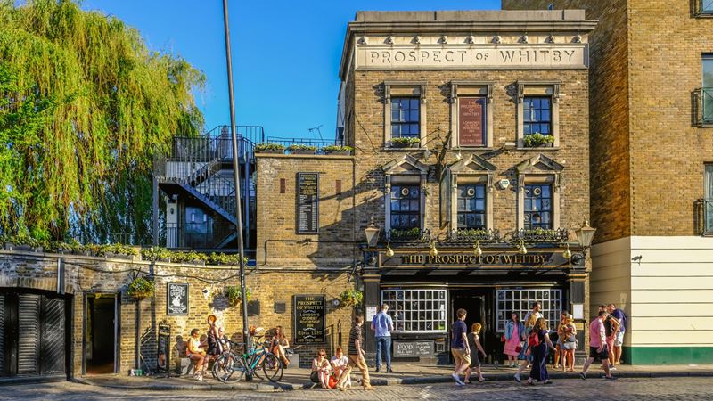 Take in the Thames riverside views from the Prospect of Whitby, one of London's oldest pubs. Credit: Shutterstock. Image courtesy of Shutterstock. A photo of the exterior of the Prospect of Whitby pub set in a large Victorian building with hanging baskets filled with flowers and people stood outside the front