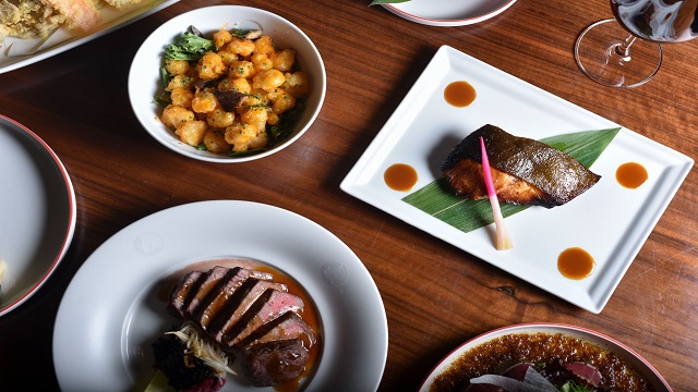 Fusion cuisine blending Japanese dishes with Peruvian ingredients at Nobu. Image courtesy of Nobu. birds eye shot of Japanese small plates presented on a wooden table