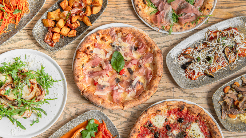 Savour a delicious range of authentic Italian dishes in this Notting Hill restaurant, which also features a large covered and heated terrace. Credit: Andy Chang. Image courtesy of Portobello Ristorante Pizzeria. A spread of pizzas, pastas and starters