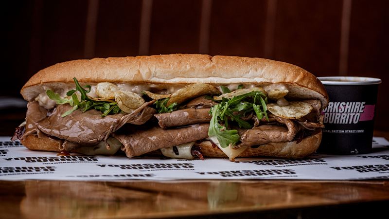 Make sure to order a side of gravy to dunk your yorkshire burrito. Credit: Yorkshire Burrito. Image courtesy of Yorkshire Burrito. A photo of a yorkshire pudding burrito filled with slices of roast beef with a side of dipping gravy