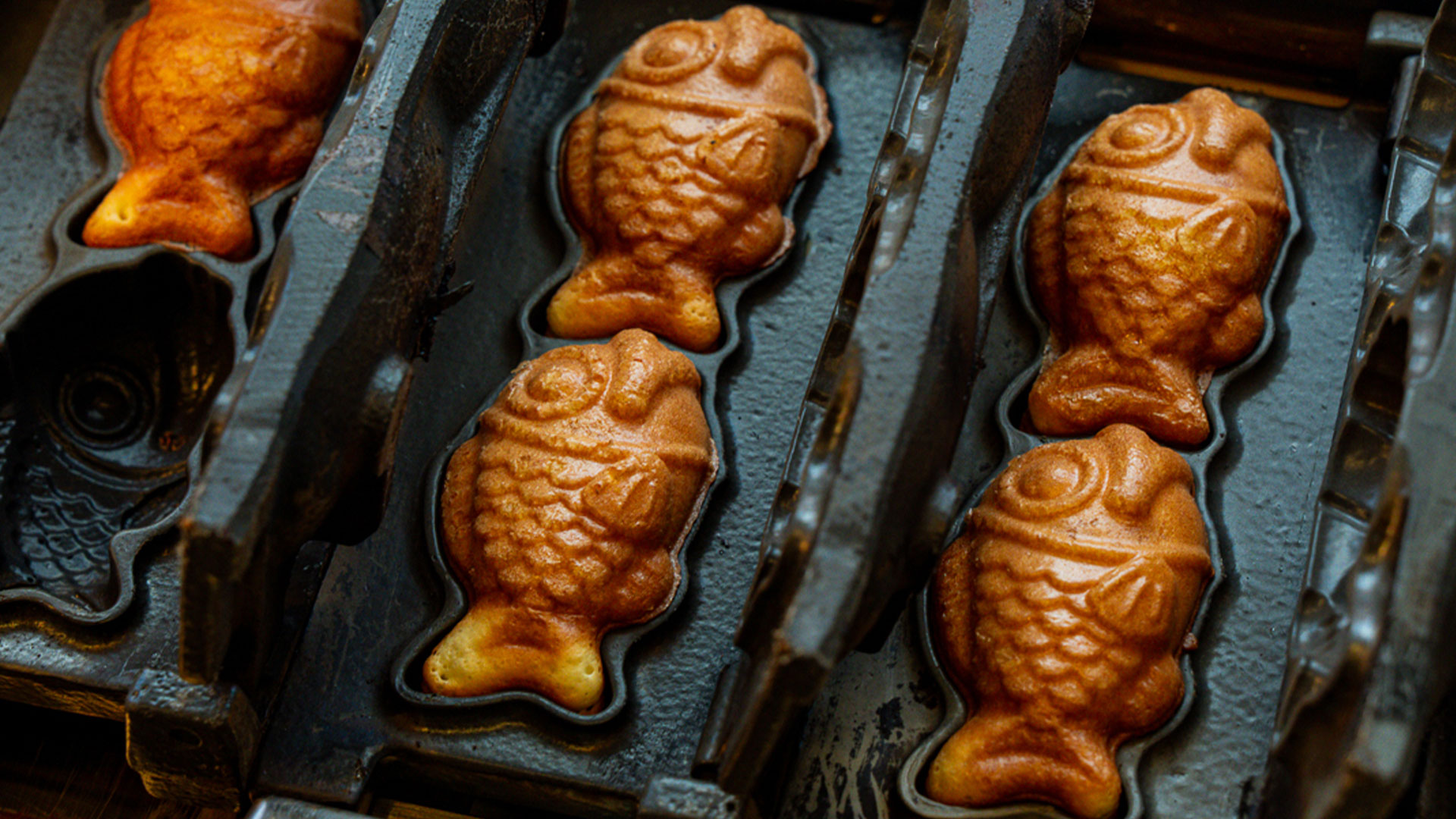 Head to Chinatown's dessert alley and try the famous Taiyaki fish waffles, which are filled with either chocolate or custard. Image courtesy of Street and Co. Black cast iron with mini Taiyaki moulds for making fish-shaped golden waffles, sold at Chinatown Bakery.