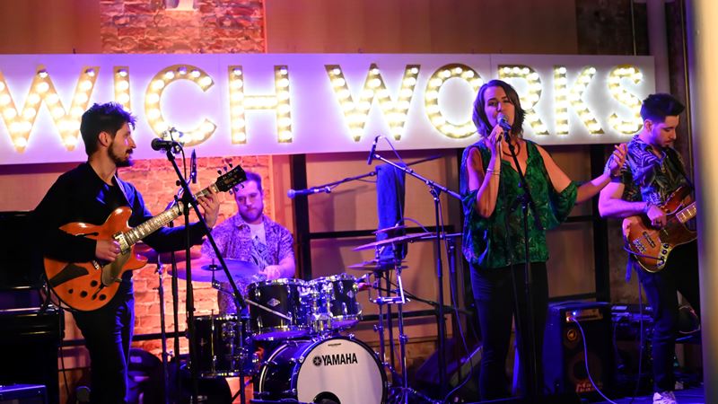 Book tickets for different events and performances at Woolwich Works. Credit: See LI. Image courtesy of Visit Greenwich. A photo of a singer and band on the stage at Woolwich Works