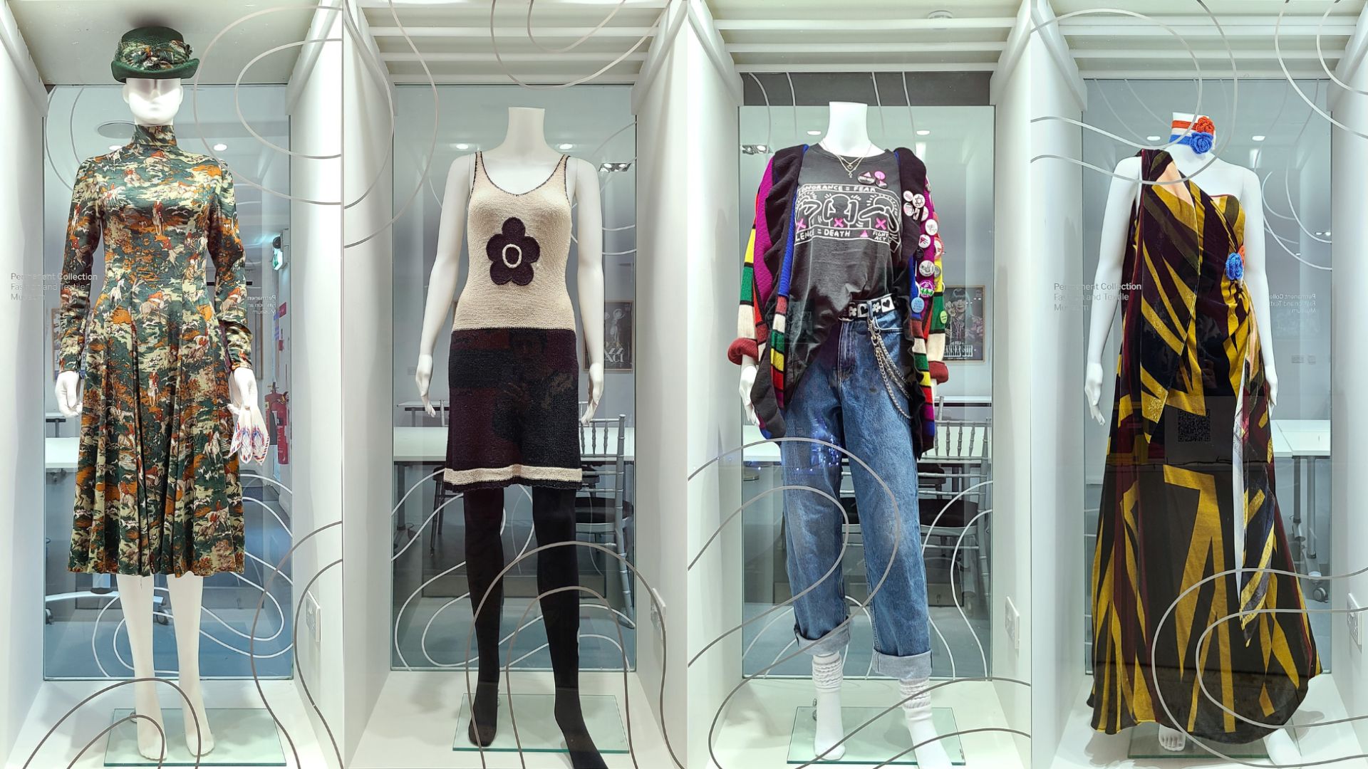 Discover Decades of Change at the Fashion and Textile Museum. Image courtesy of the Fashion and Textile Museum. Four different outfits side by side in glass cases as part of the permanent exhibition at the Fashion and Textile Museum.
