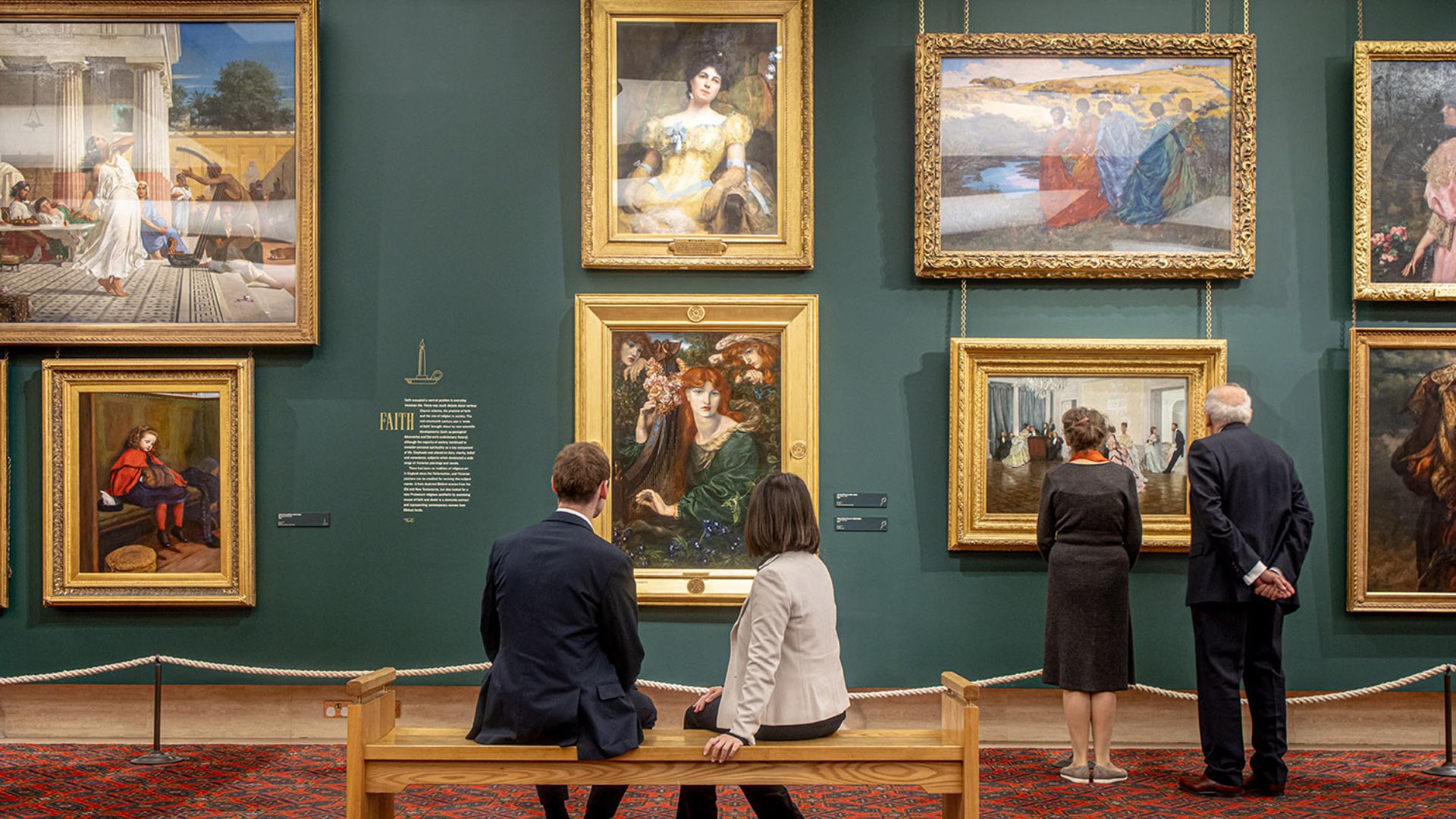 Discover paintings from 1670 to the 21st century at Guildhall Art Gallery. Image courtesy of Guildhall Art Gallery. Two people sitting and two other people standing in front of paintings at Guildhall Art Gallery.