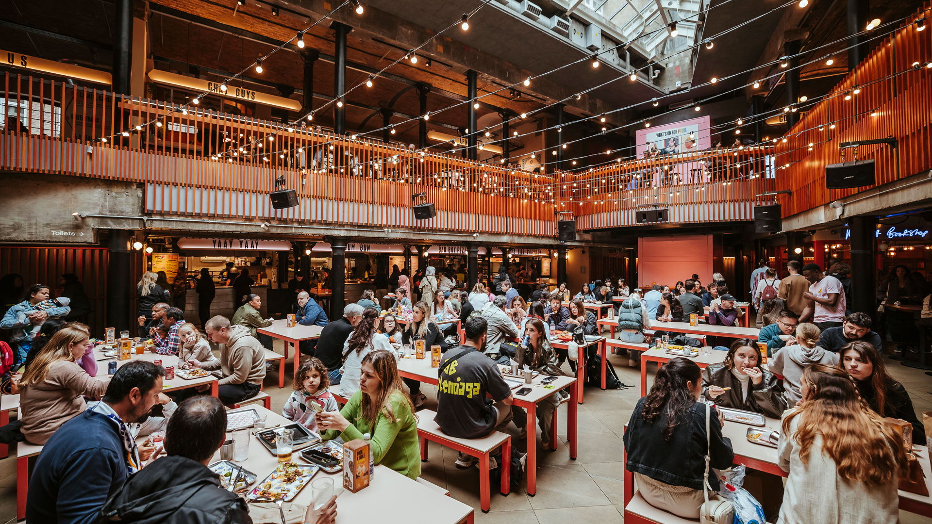 Inside Seven Dials Market. Credit: Ryan Dinham. Image courtesy of KERB Group. People sat eating and drinking at tables inside Seven Dials Market.