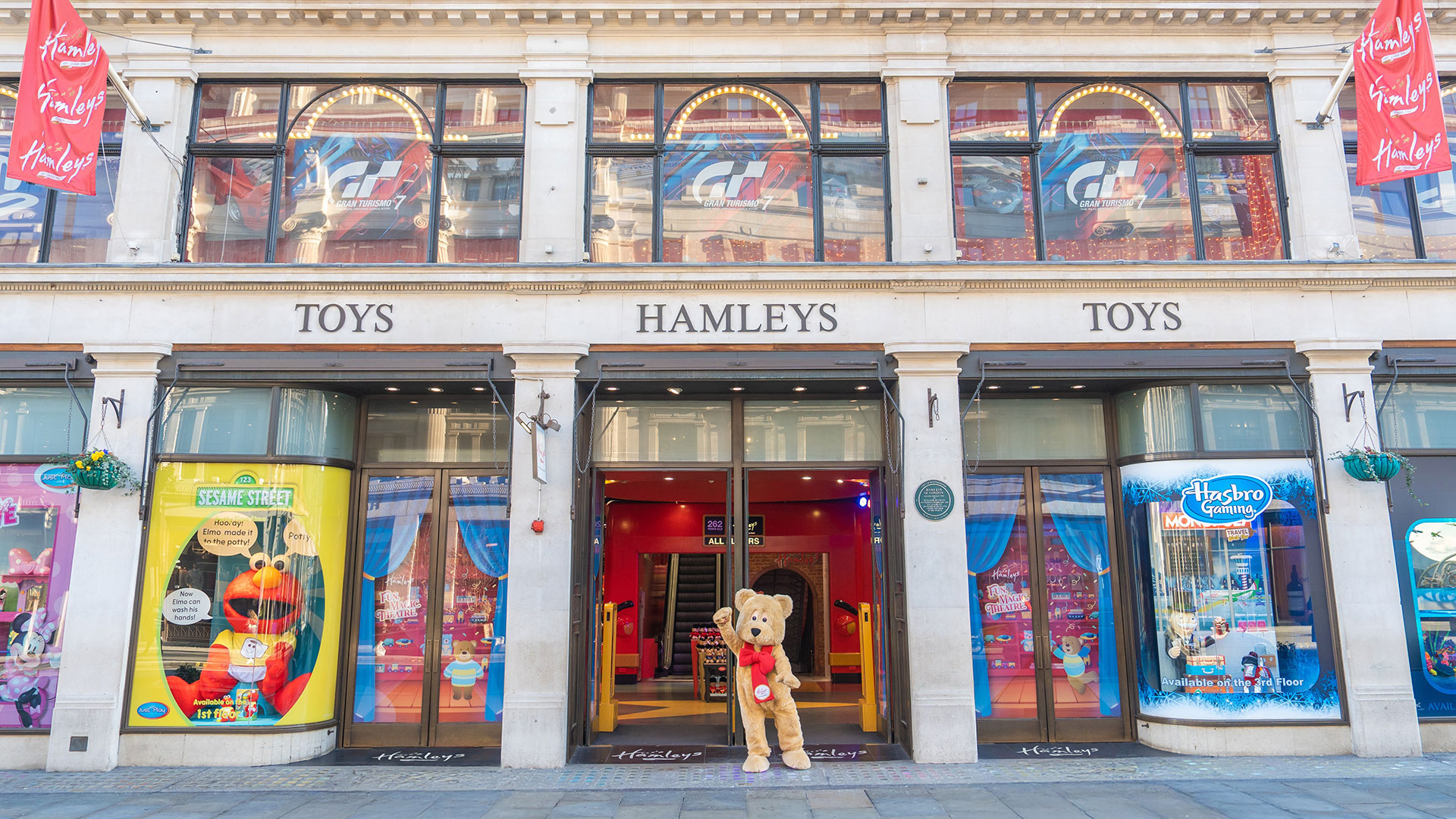 Hamleys is a magical experience with seven floors of toys, games, live entertainment and in-store events. Image courtesy of Hamleys. A giant golden bear with a red bow waving in front of Hamleys