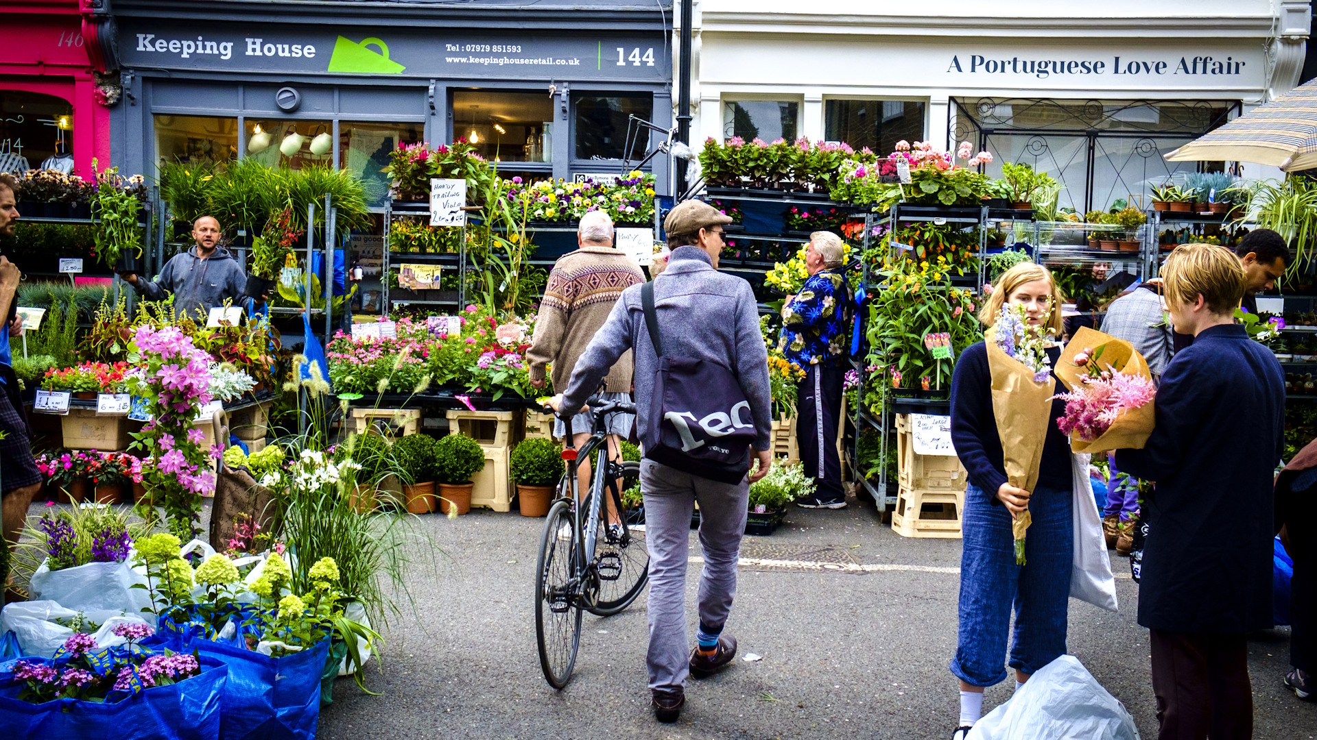 Experience vibrant Columbia Road Flower Market on a Sunday. Credit: Shutterstock. Image courtesy of Shutterstock. A man with a bicycle browses the flower-filled stalls of Columbia Road Flower Market.