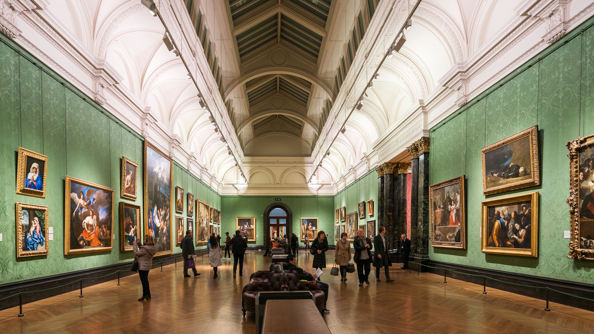 The National Gallery hosts some of the world's most famous paintings © visitlondon.com/Jon Reid The interior of one of the rooms at The National Gallery, featuring green walls and numerous framed paintings.