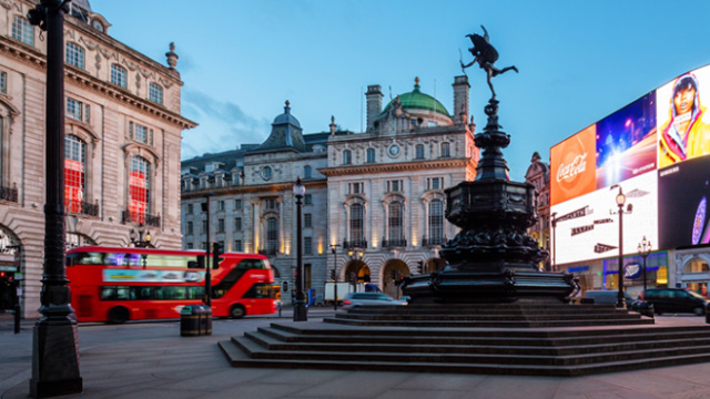 Piccadilly Circus and the statue of Eros © visitlondon.com/Jon Reid. Image courtesy of visitlondon.com/Jon Reid / Photos.London. Piccadilly Circus at dusk, with the statue of Eros in the foreground, and a red London bus and the iconic wall of LED lights in the background.