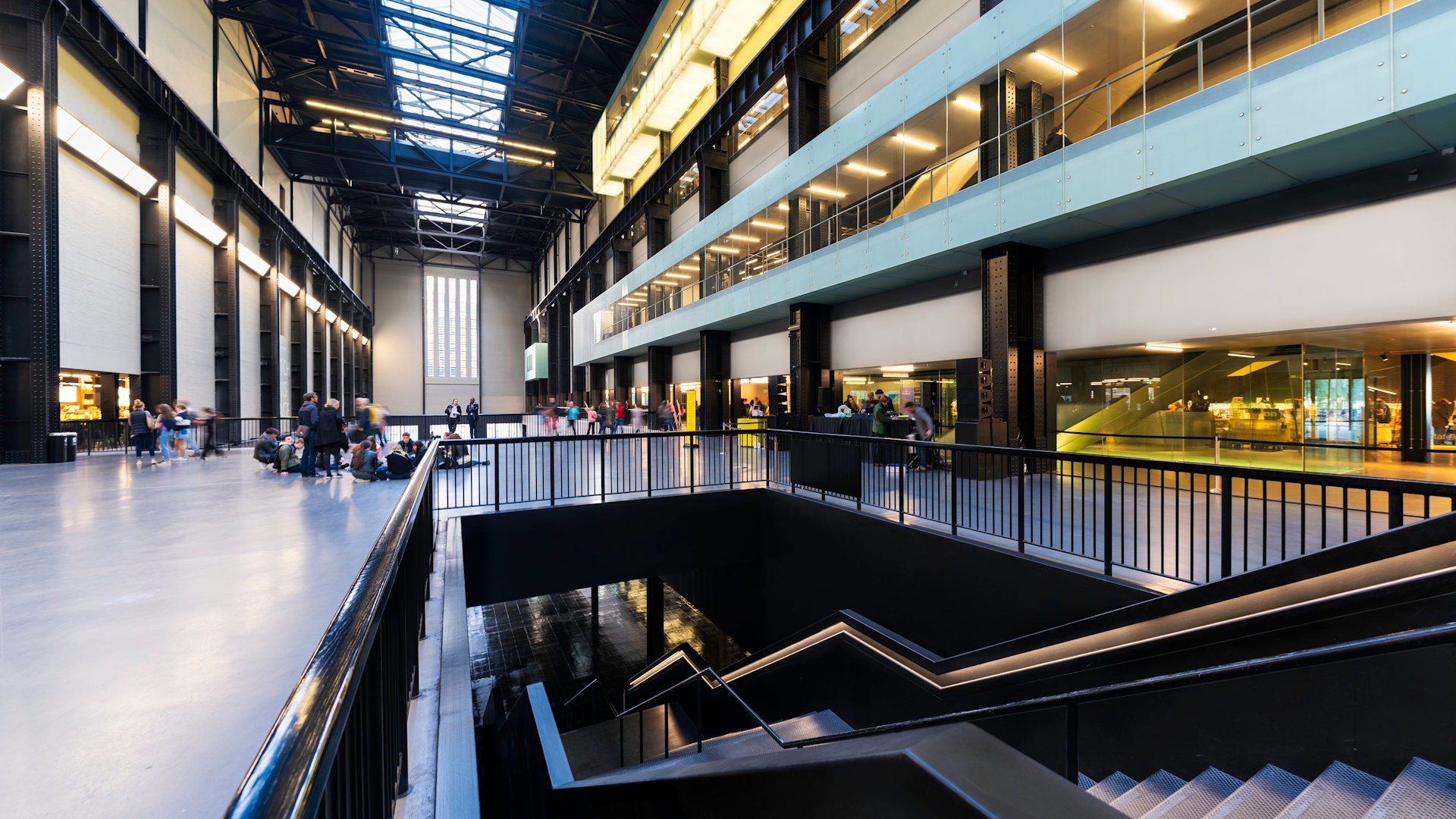 Turbine Hall at Tate Modern © Jon Reid / London & Partners. An interior view of the Turbine Hall at Tate Modern featuring a concourse and desks on the right.