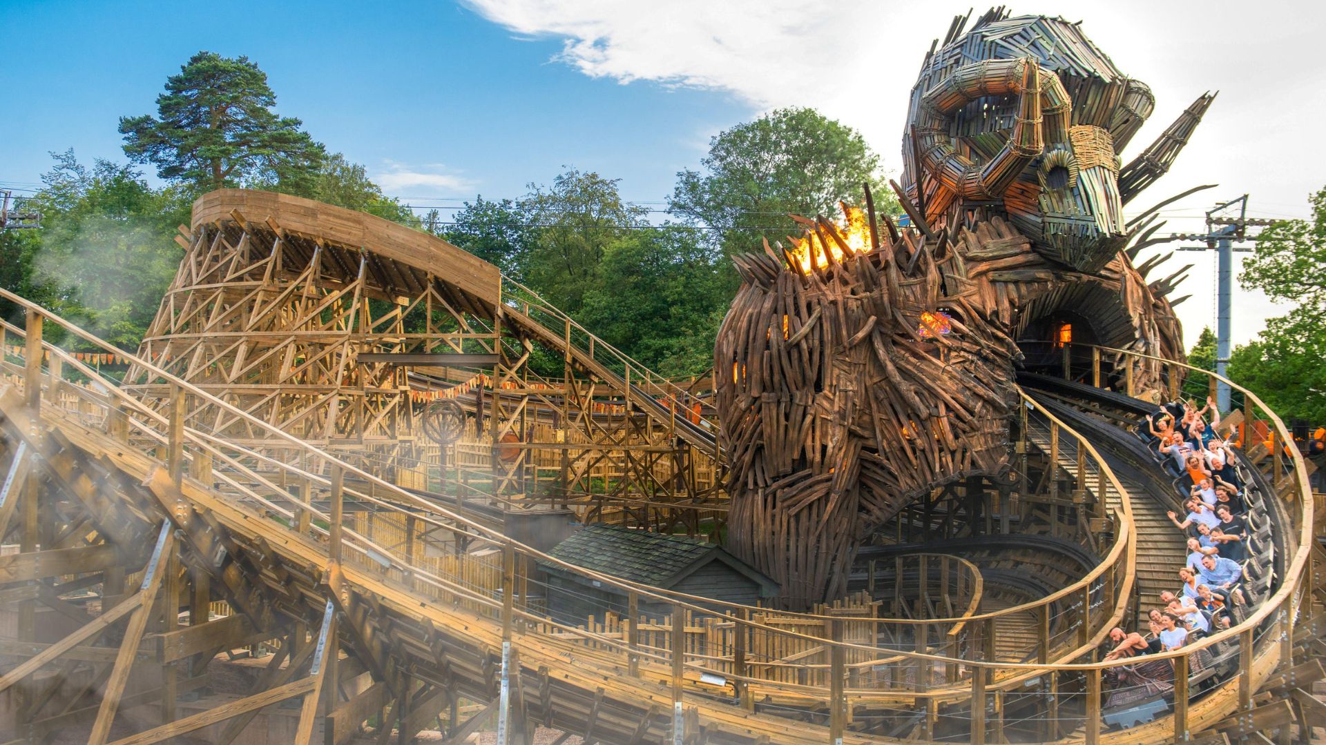 Experience the thrill of the Wicker Man at Alton Towers Resort. Image courtesy of Merlin. The Wicker Man wooden roller coaster at Alton Towers, with the train passing through a giant flaming wicker structure.