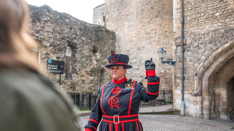 Unlock the secrets of the Tower of London on a Beefeater tour. Image courtesy of London & Partners/Michael Barrow. A female beefeater is leading a tour at the Tower of London.