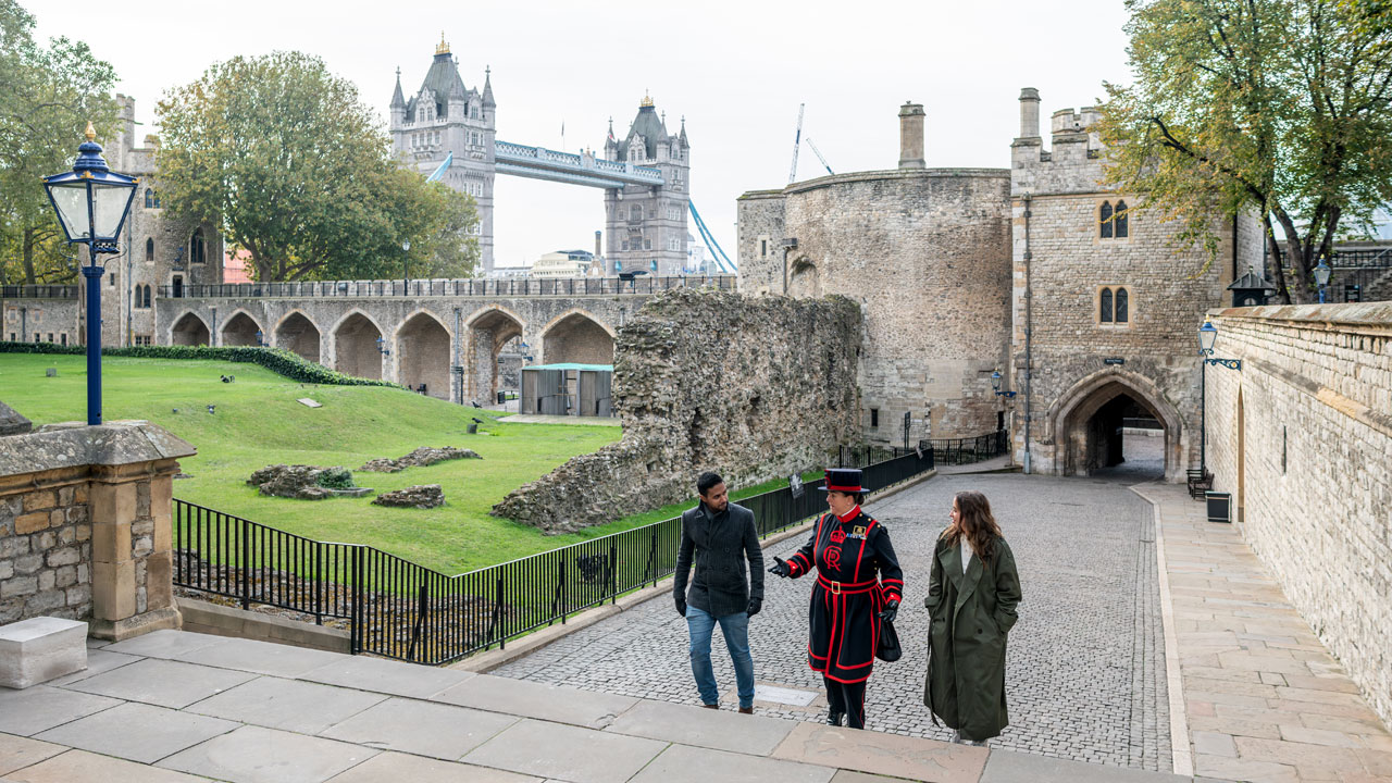Explore the Tower of London and learn about its different functions over the years, guided by a Beefeater. ©London & Partners/Michael Barrow A man and a woman are walking around the Tower of London during a guided tour led by a Beefeater.