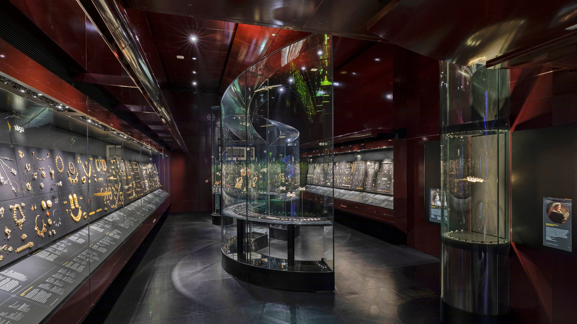 V&A William and Judith Bollinger Gallery © Victoria and Albert Museum, London. Image courtesy of Victoria and Albert Museum. The William and Judith Bollinger Gallery, featuring low lighting and display cases full of jewellery.