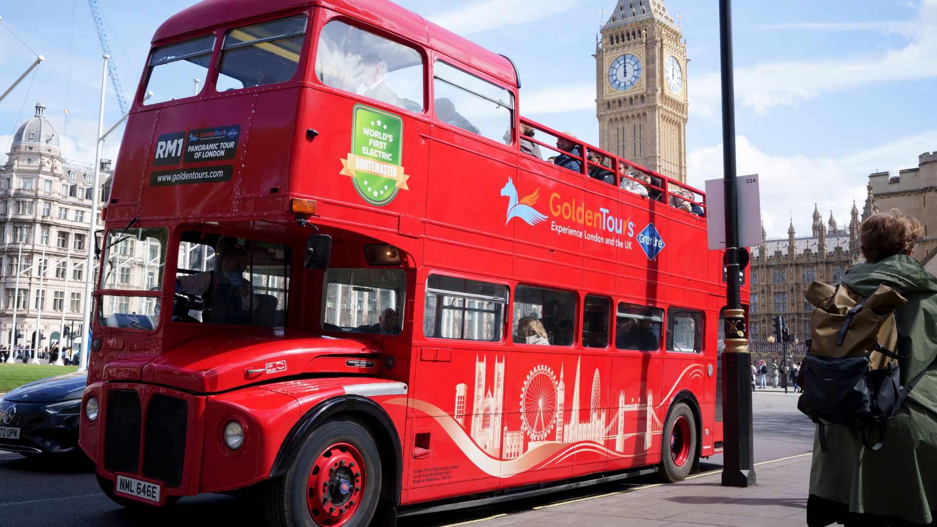 Hop aboard a vintage Routemaster bus for a live-guided panoramic tour of London. Image courtesy of Golden Tours. Vintage Routemaster bus driving through London with Big Ben in the background.