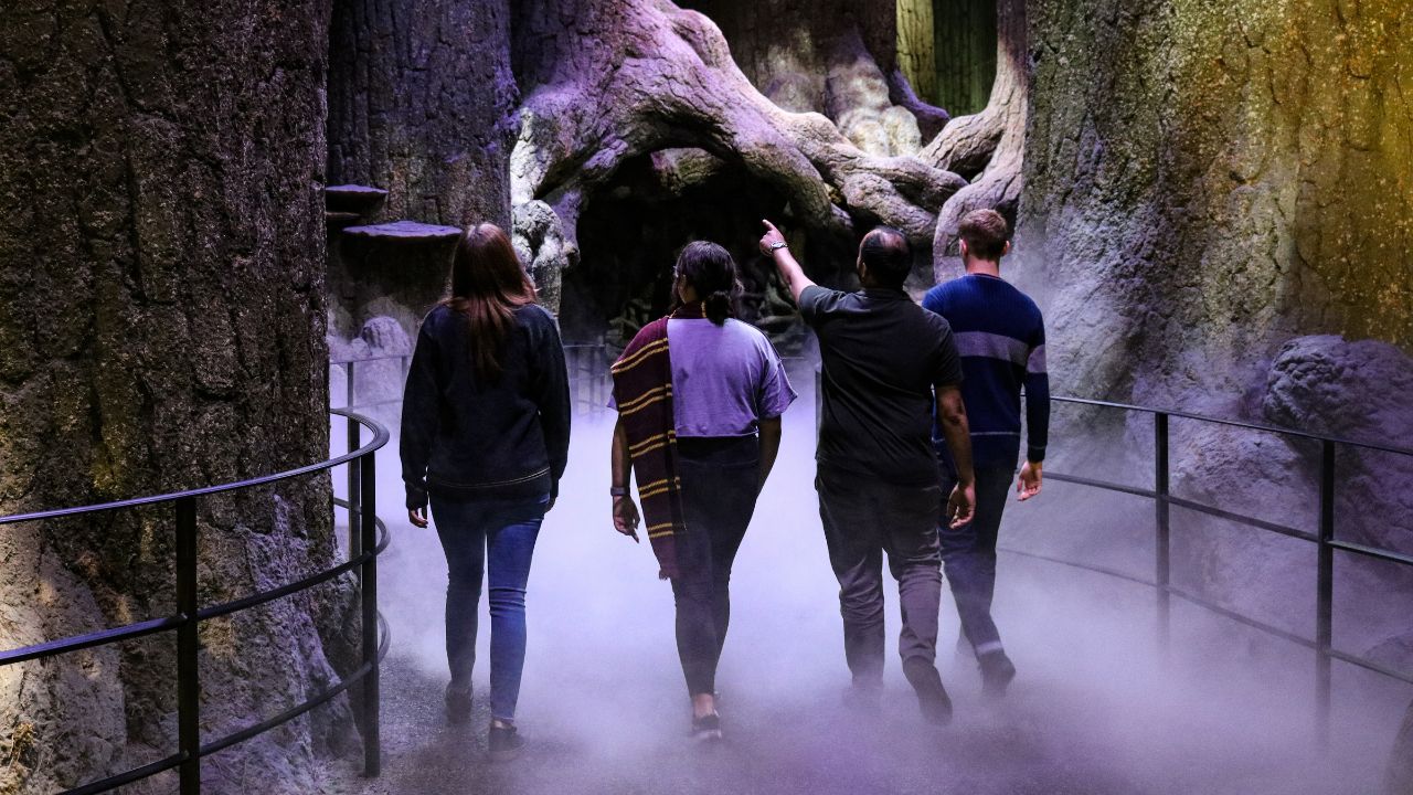 Board the Hogwarts Express! TM & © Warner Bros. Entertainment Inc. Harry Potter Publishing Rights © JKR. Four people walk through the forbidden forest at the warner bros studio tour