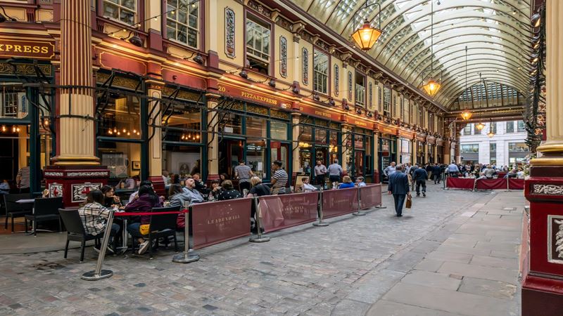 Can you recognise Leadenhall Market from scenes in Harry Potter? Credit: London & Partners/Michael Barrow. Image courtesy of London & Partners. long angle shot of inside Leadenhall Market, with Victorian decor and people sitting outside a pub in the market