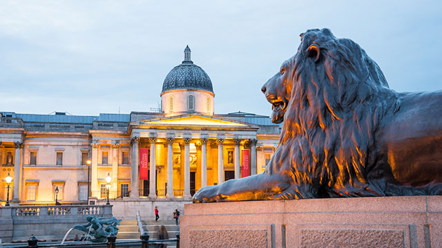 A Trafalgar Square lion at dusk © Shutterstock / alice-photo. Image courtesy of Shutterstock / alice-photo / Photos.London. A Trafalgar Square lion at dusk in front of the National Gallery