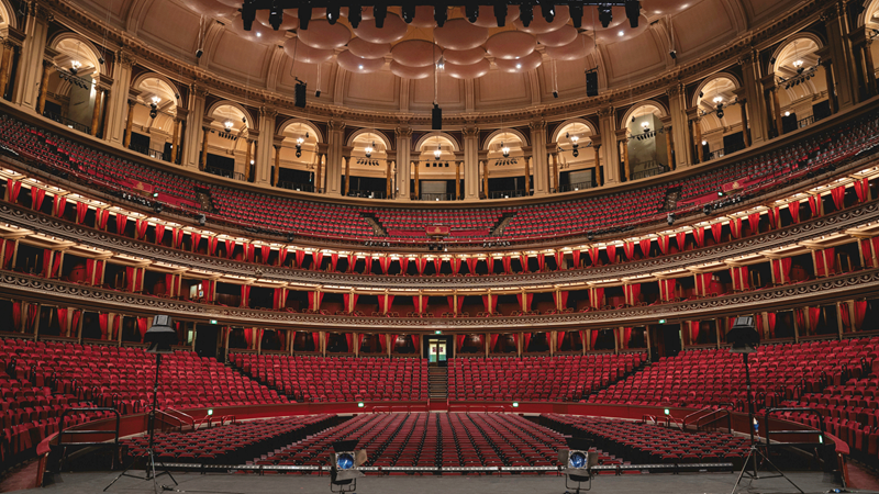Relax in the red velvet seats at the Royal Albert Hall while you enjoy magnificent performances during BBC Proms. Credit: Royal Albert Hall. Image courtesy of Royal Albert Hall. A photo from the stage of the Royal Albert Hall seating area
