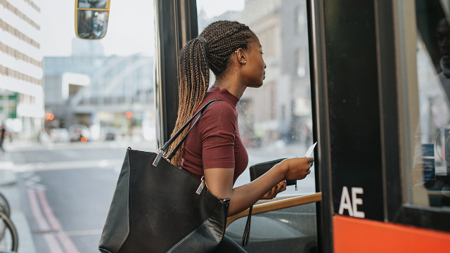 Voyager à bord d'un bus de Londres. Image fournie par Shutterstock Une jeune femme de couleur entre à bord d'un bus