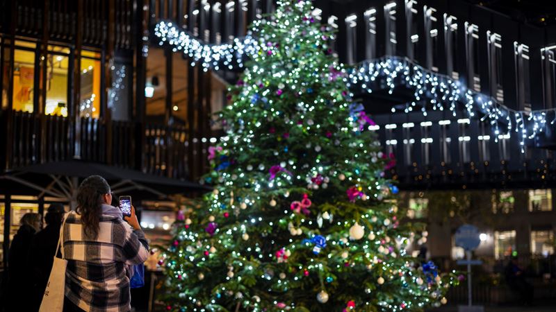 Try to spot all five Christmas trees dotted around Camden Market this Christmas! Credit: Camden Market. Image courtesy of Camden Market. A large Christmas tree covered in twinkling lights and baubles stands outside of the Cyberdog shop in Camden Market, next to two giant silver robots wearing santa hats stood outside the shop entrance
