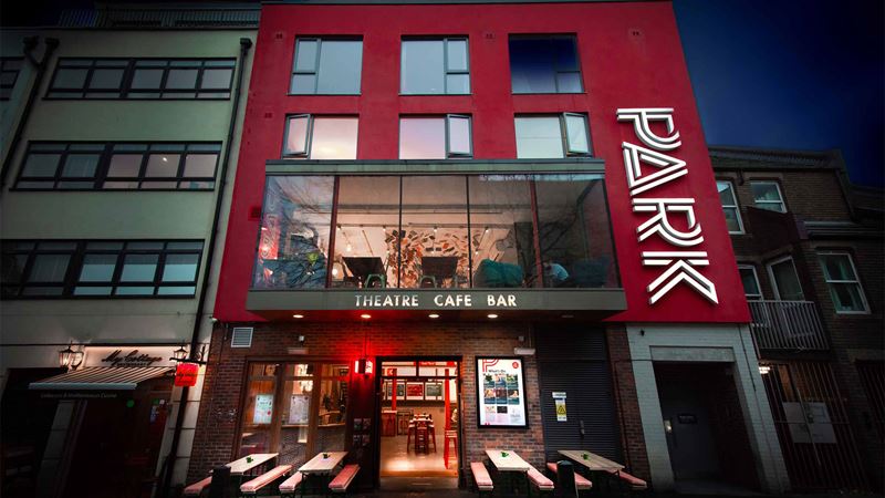 Enjoy a variety of classic plays, revivals and new works by emerging writers at Park Theatre. Image courtesy of Piers Foley. A modern building with a red façade stands with the letters 'Park' on the right-hand side. This is the main entrance to the Park Theatre in London.