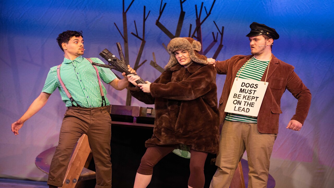 Discover an adaptation of the much-loved Stick Man books by multi-award-winning author Julia Donaldson. Image courtesy of Mark Senior PR. Stick Man in conflict with two other characters on stage, one with 'dogs must be kept on lead' sign.