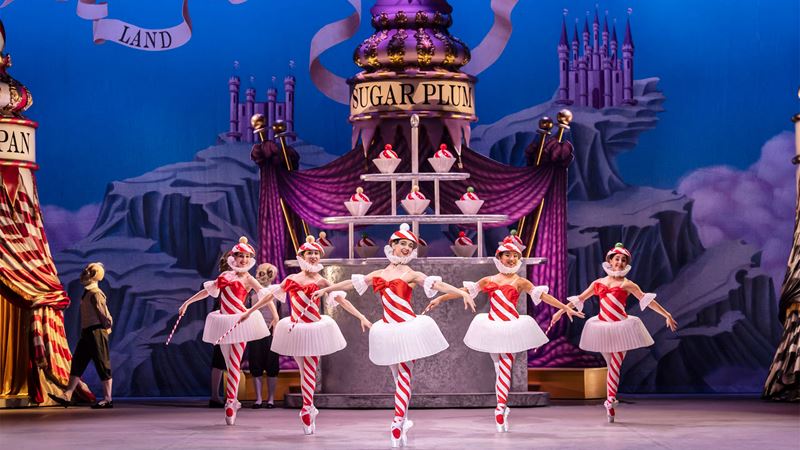 Watch the English National Ballet's magical production of The Nutcracker at London Coliseum. Image courtesy of London Theatre Direct. During the production of The Nutcracker Ballet at the London Coliseum, five ballet dancers wearing red and white striped tights and bodices are dancing on stage.