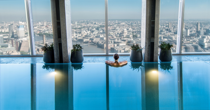 Unwind above the city in Shangri-La The Shard's infinity pool. Credit: Shangri-La The Shard. Image courtesy of Shangri-La The Shard. Woman looks out over London skyline from Shangri-La The Shard Sky Pool